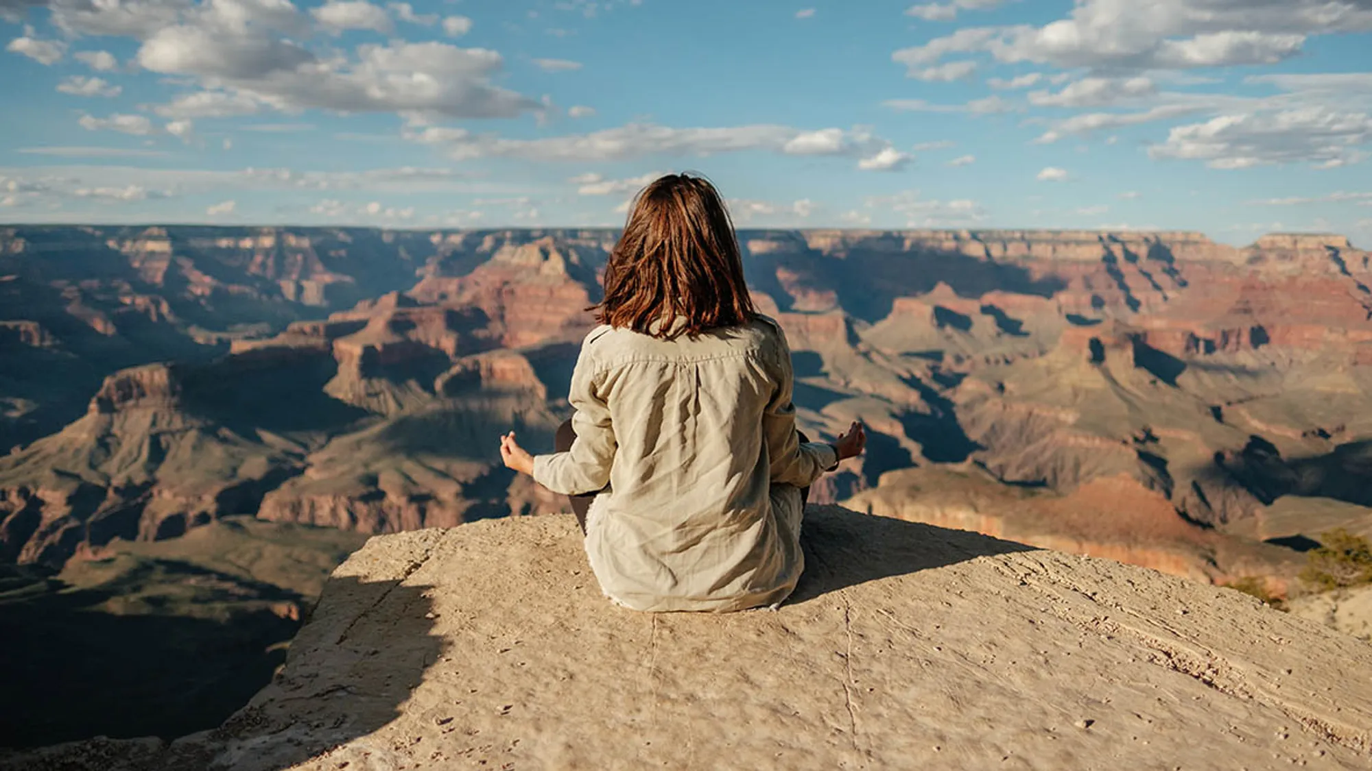 Meditation lernen: Frau meditiert auf einem Berg