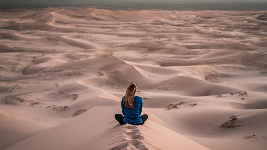 Feucht werden: Frau sitzt in der Wüste