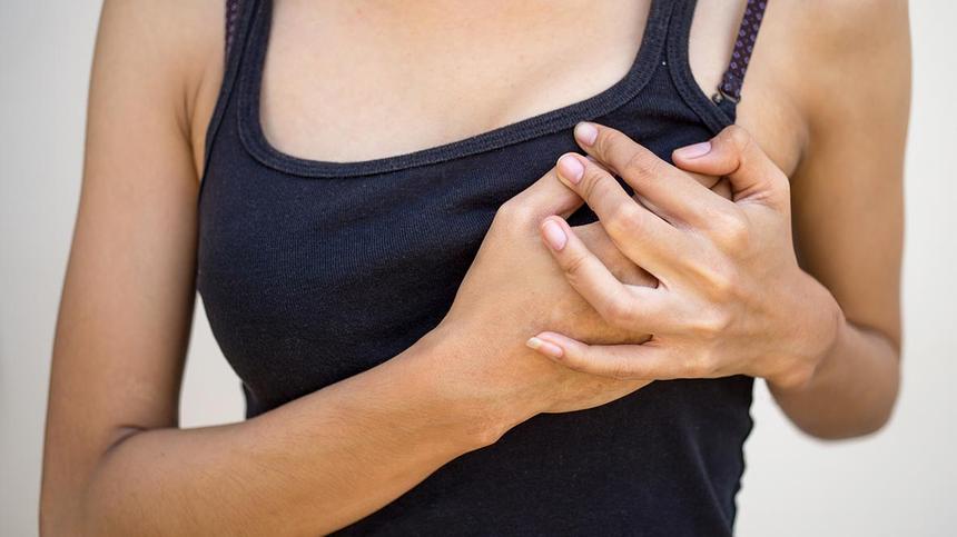 Brustdrüsenentzündung: Frau fasst sich an die Brust