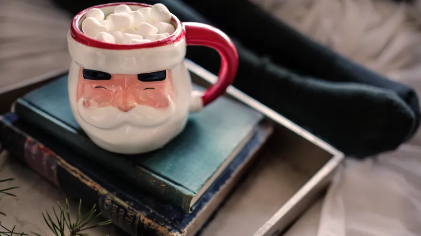 Weihnachtsmann Tasse steht auf einem Bücherstapel