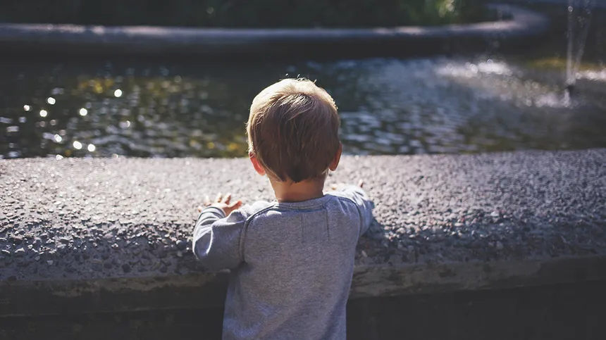 Ein kleiner Junge schaut auf einen Fluss