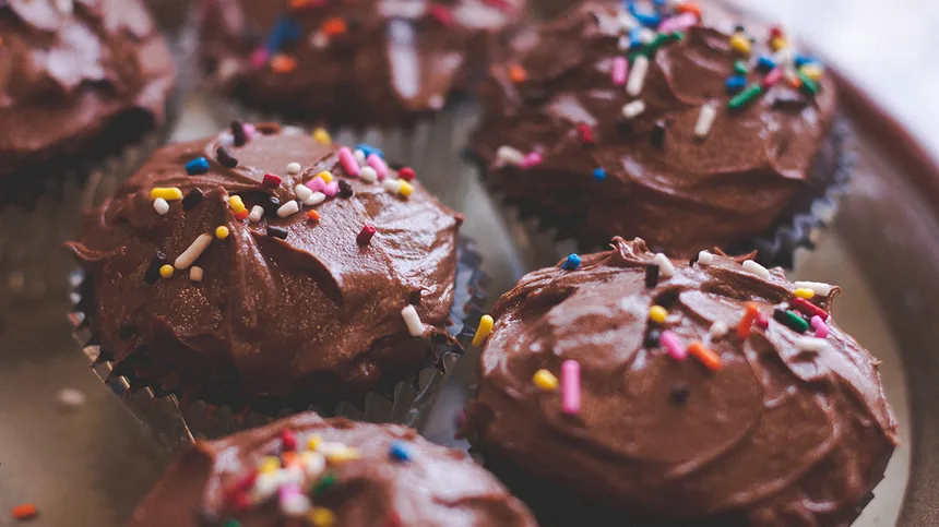 Cupcakes mit Schokoladen-Buttercreme und bunten Streuseln