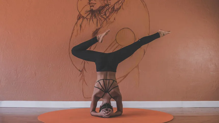 Frau macht eine Yogaübung vor einer Wand