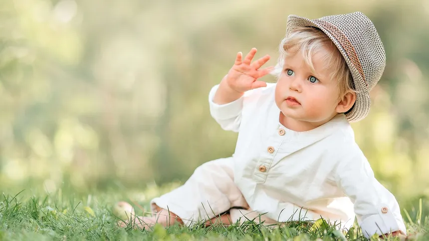 Kleinkind mit Hut auf Wiese