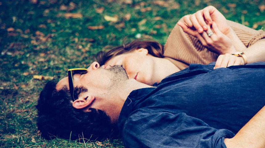 Frau und Mann liegen im Gras und schlafen