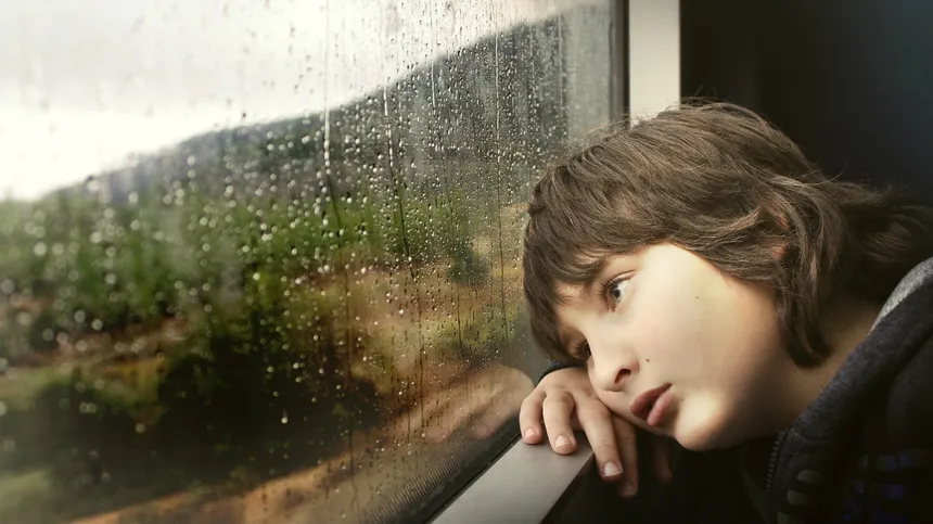 Ein Junge starrt aus dem Zugfenster