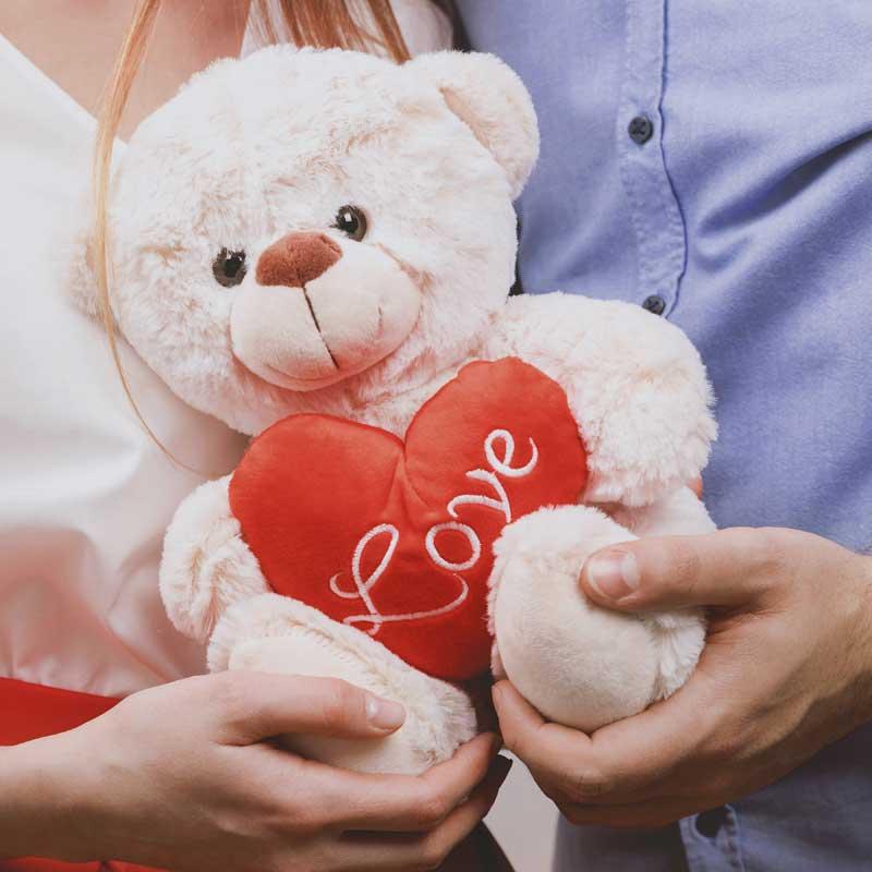 Mann und Frau halten einen Teddybär