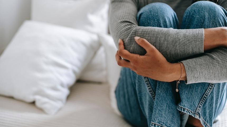 Abort nach Blasenmole: trauernde Frau sitzt auf Bett