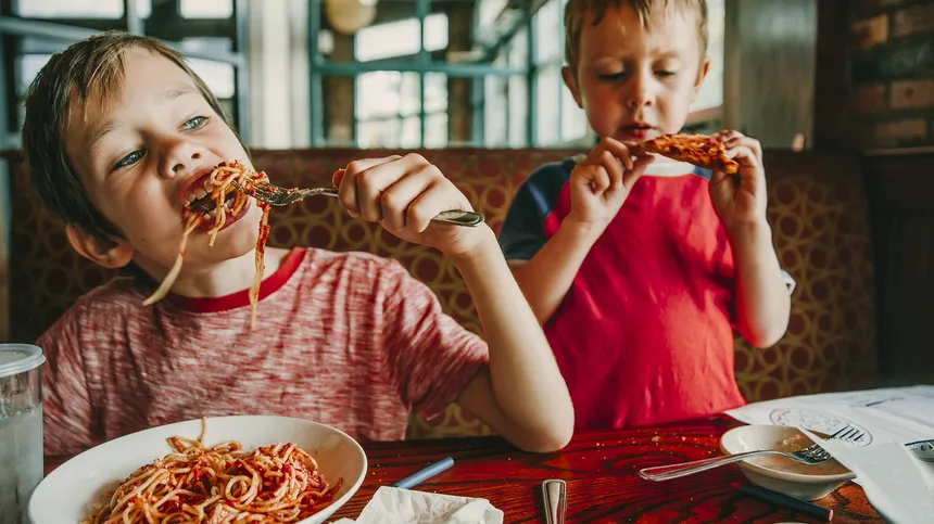 Kinder essen in einem Restaurant Pizza und Pasta