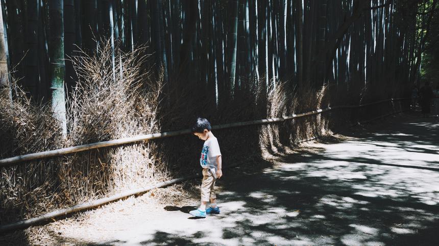 Kleines Kind steht im Wald