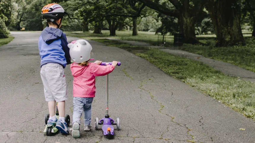 Kinder fahren Roller in einem Park