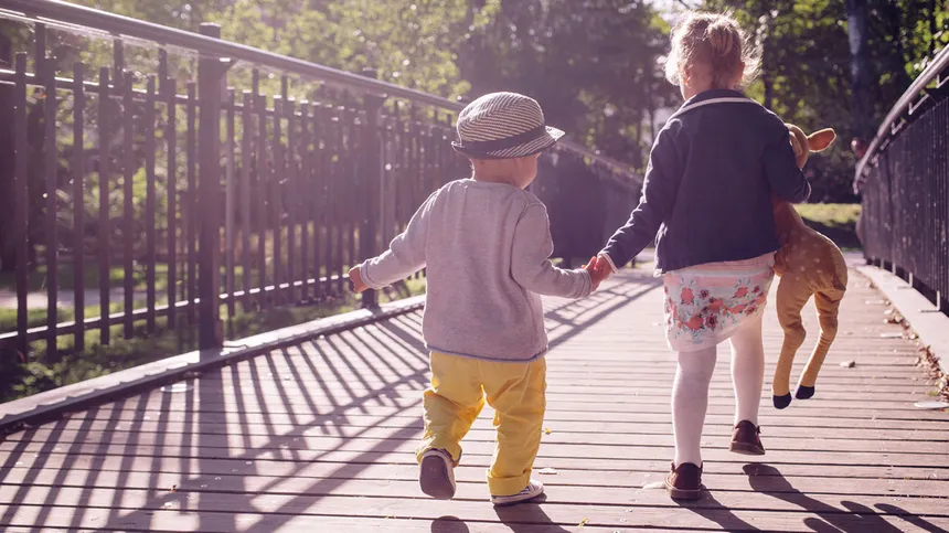Zwei Kinder gehen über eine Brücke.