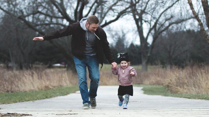 Vater und Tochter laufen zusammen im Park