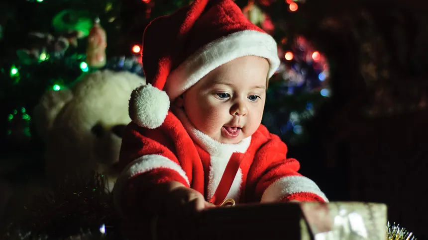 Baby öffnet ein Weihnachtsgeschenk