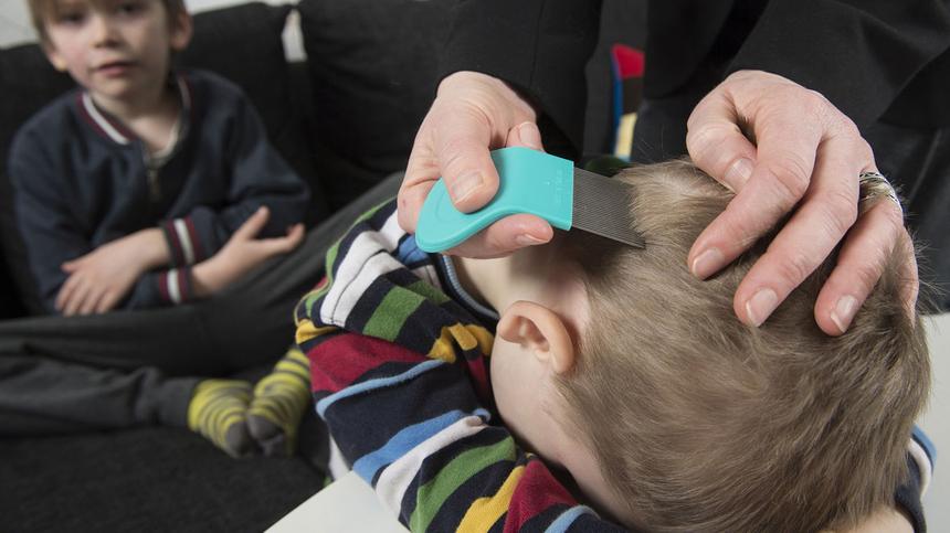 Mutter untersucht Jungen auf Kopfläuse