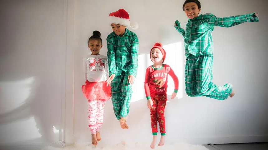 Kinder in weihnachtlichen Schlafanzügen springen