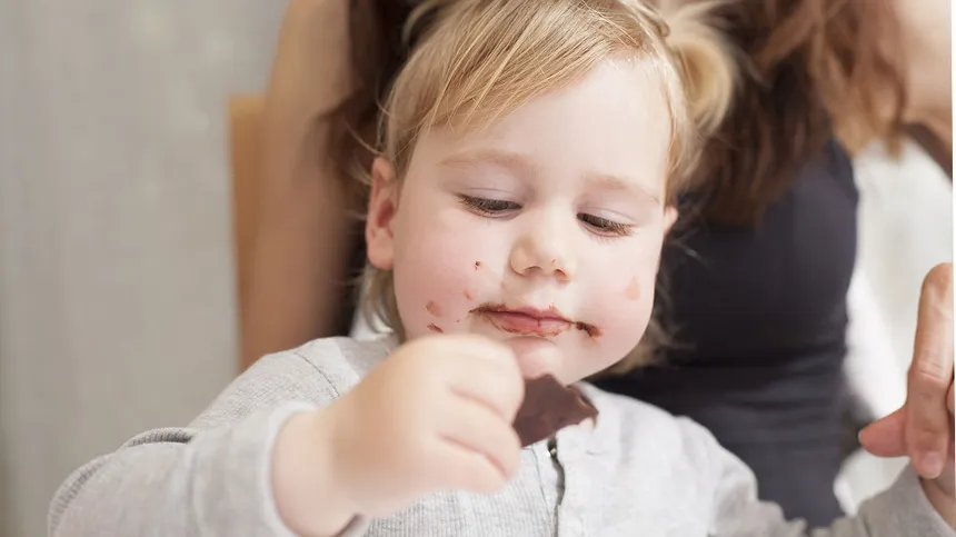 Kind isst ein Stück Schokolade