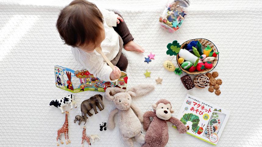 Kind spielt mit verschiedenen Spielsachen