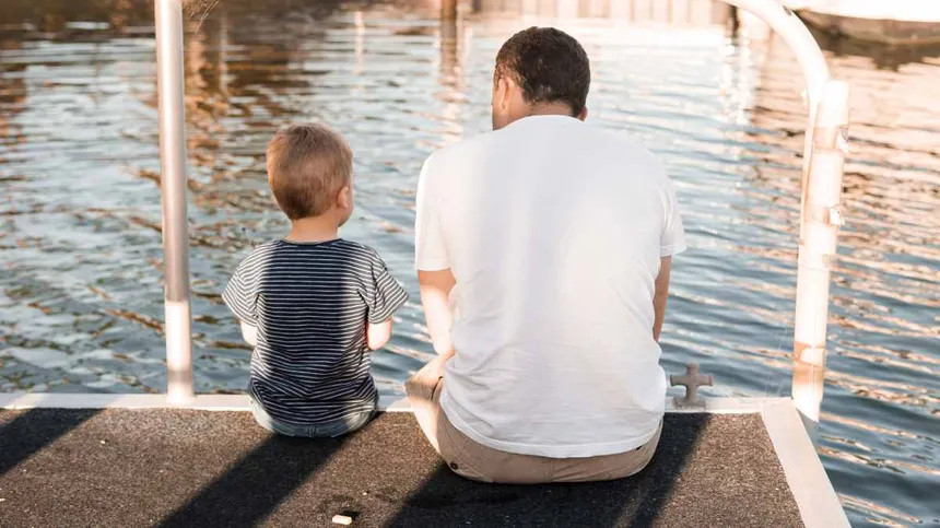 Vater und Sohn sitzen am Wasser