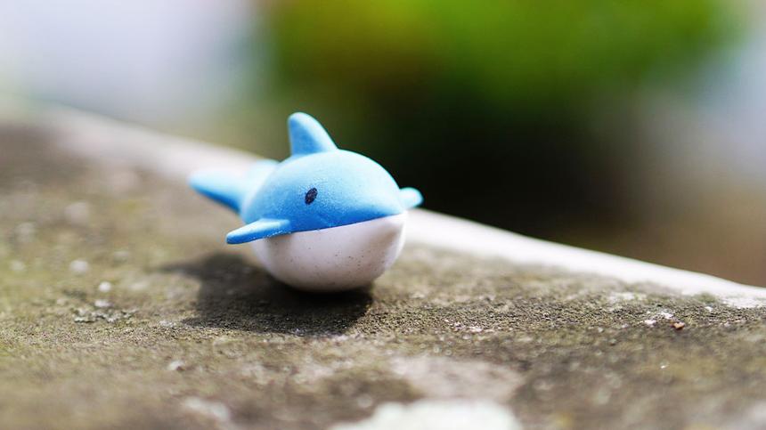 Ein Spielzeug Wal liegt auf einer Steinmauer