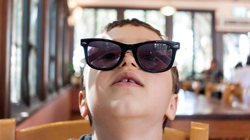 Kind mit einer Sonnenbrille im Gesicht