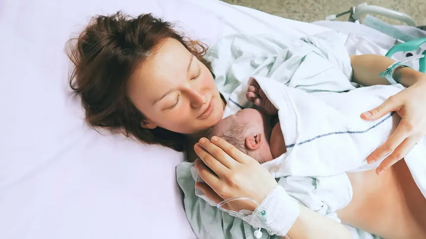 Mutter hält ihr Neugeborenes im Arm