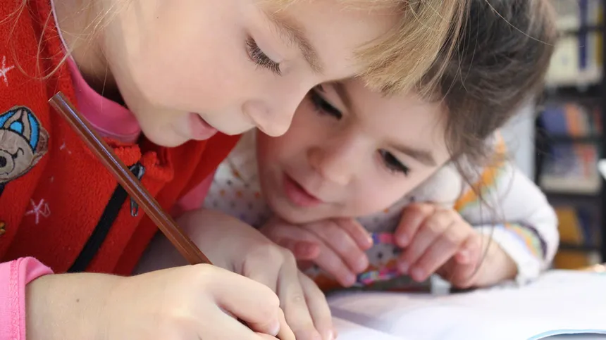 Lerntypentest - Zwei Mädchen schreiben auf ein Blatt