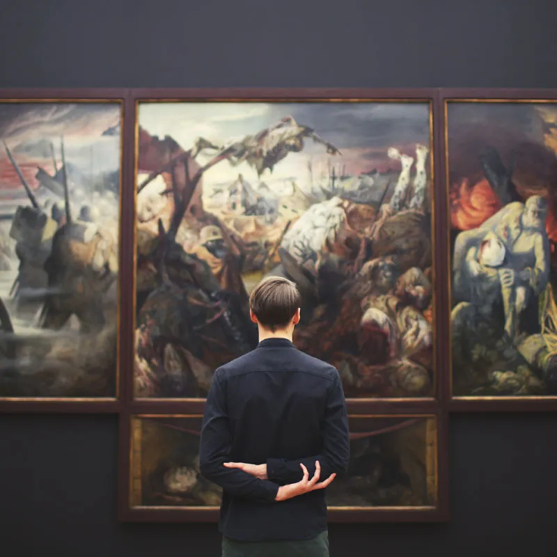 Mann steht in Museum vor einem Gemälde