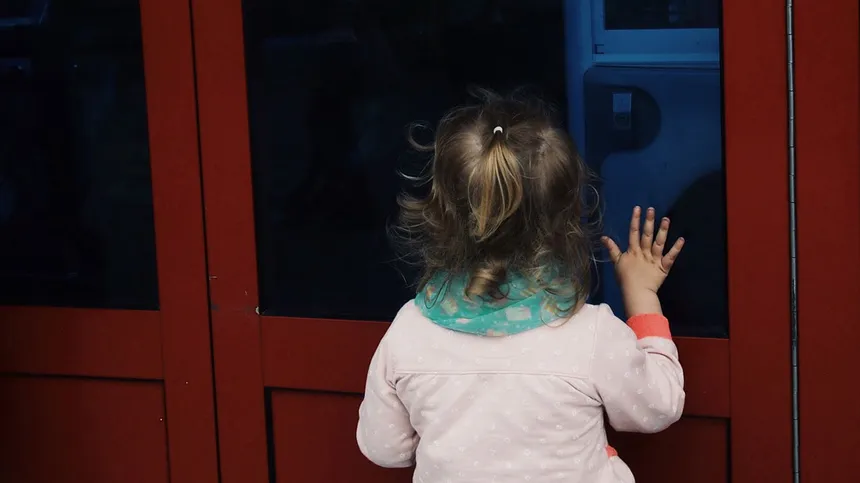 Kleines Mädchen steht vor verschlossener Türe