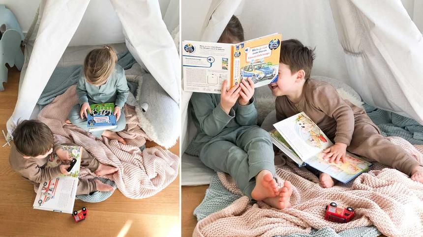 Kinder lesen zusammen in einem Tipi