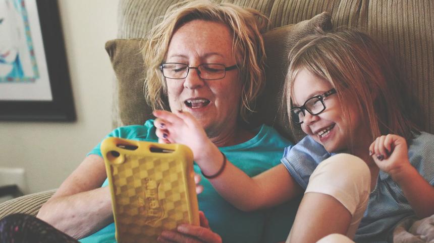 Oma und Enkelin schauen auf ein Tablet