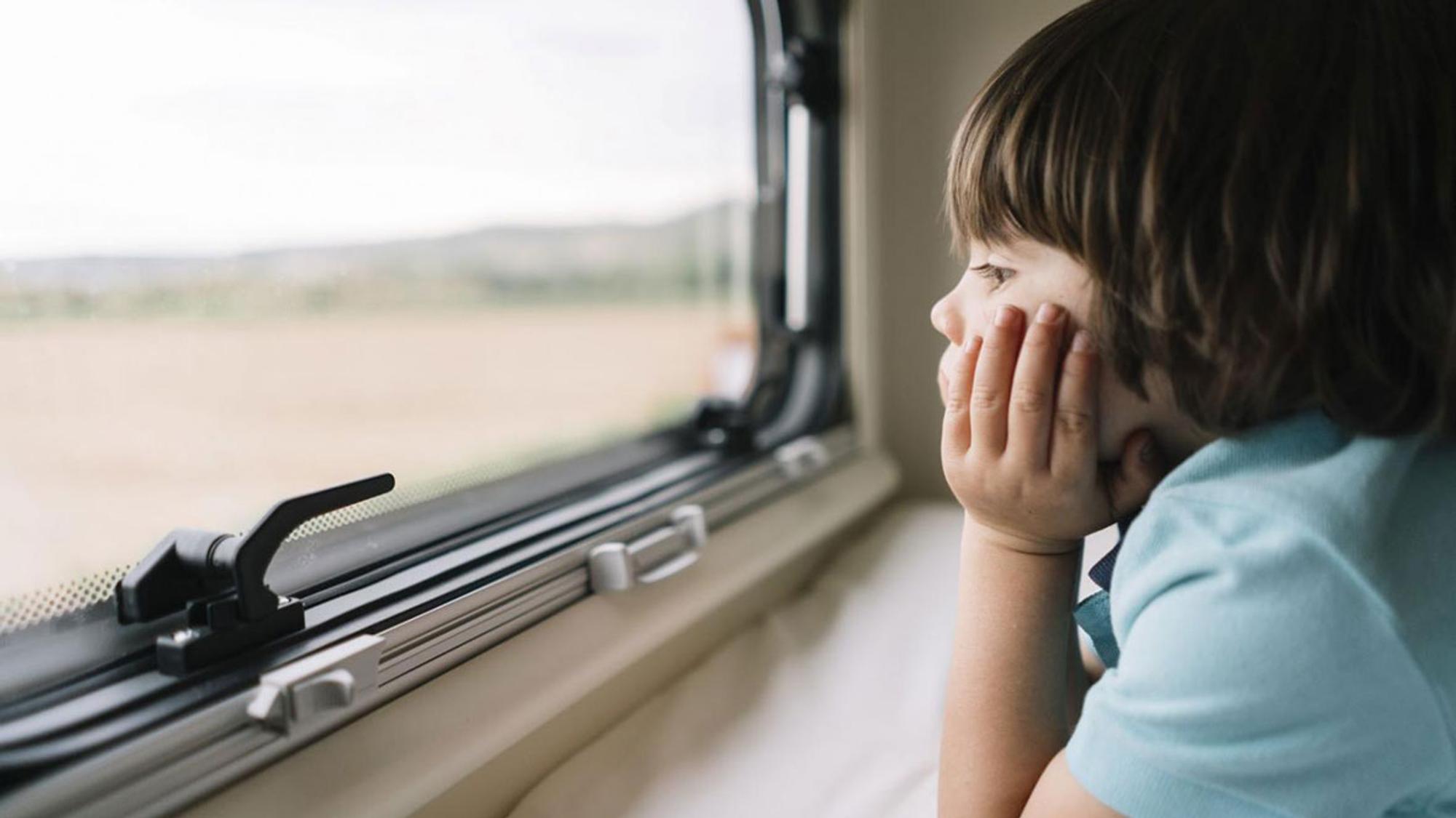 Kind schaut aus einem Wohnmobil-Fenster