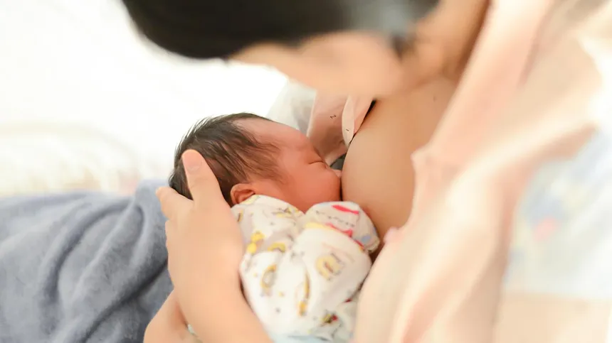 Frau stillt ihr Baby nach Milcheinschuss