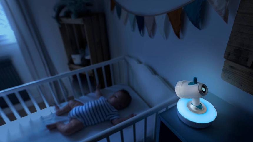Baby liegt im Bettchen mit aktivem Babyphone