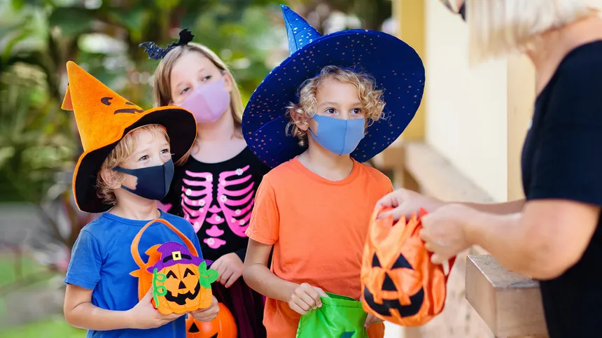 Kinder fragen nach Süßigkeiten mit Maske