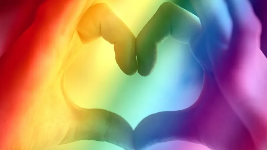 Finger bilden Herz in Regenbogenfarben