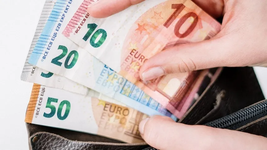 Hand zieht Euro-Geldscheine aus einem Geldbeutel