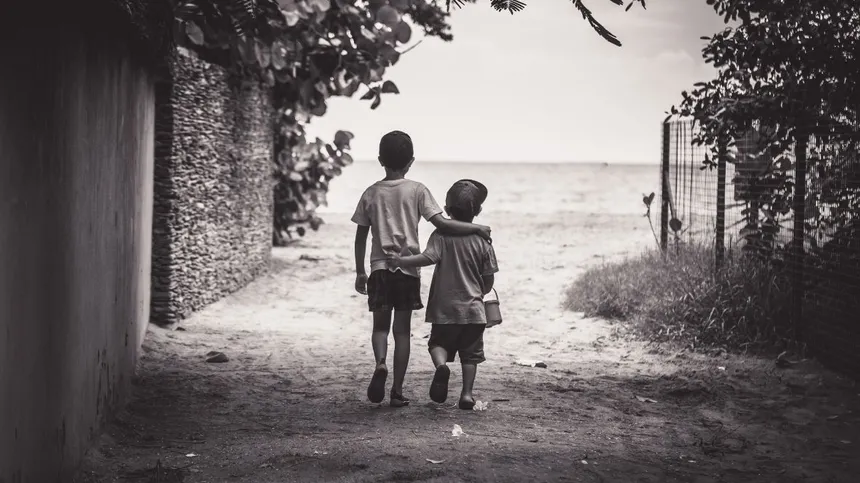 Zwei Jungen gehen nebeneinander Arm in Arm, schwarz-weiß