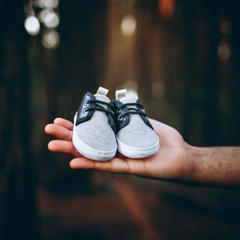 Mann hält Baby-Schuhe