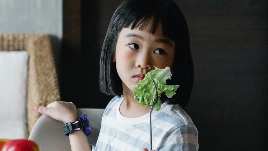 Mädchen hat Salatblatt auf einer Gabel