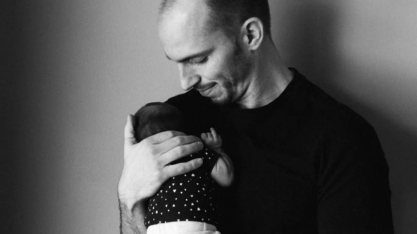 Schwarz-weiß Bild von Vater mit Baby aufm Arm