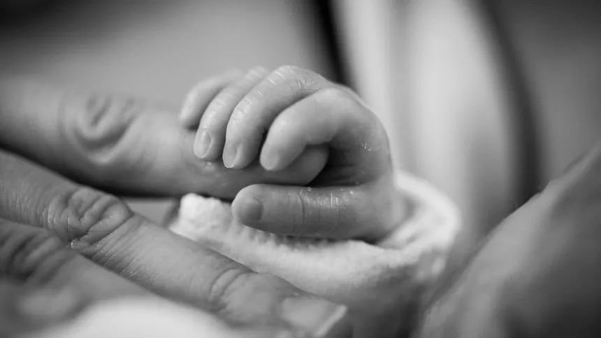 Baby hält Finger in schwarz-weiß