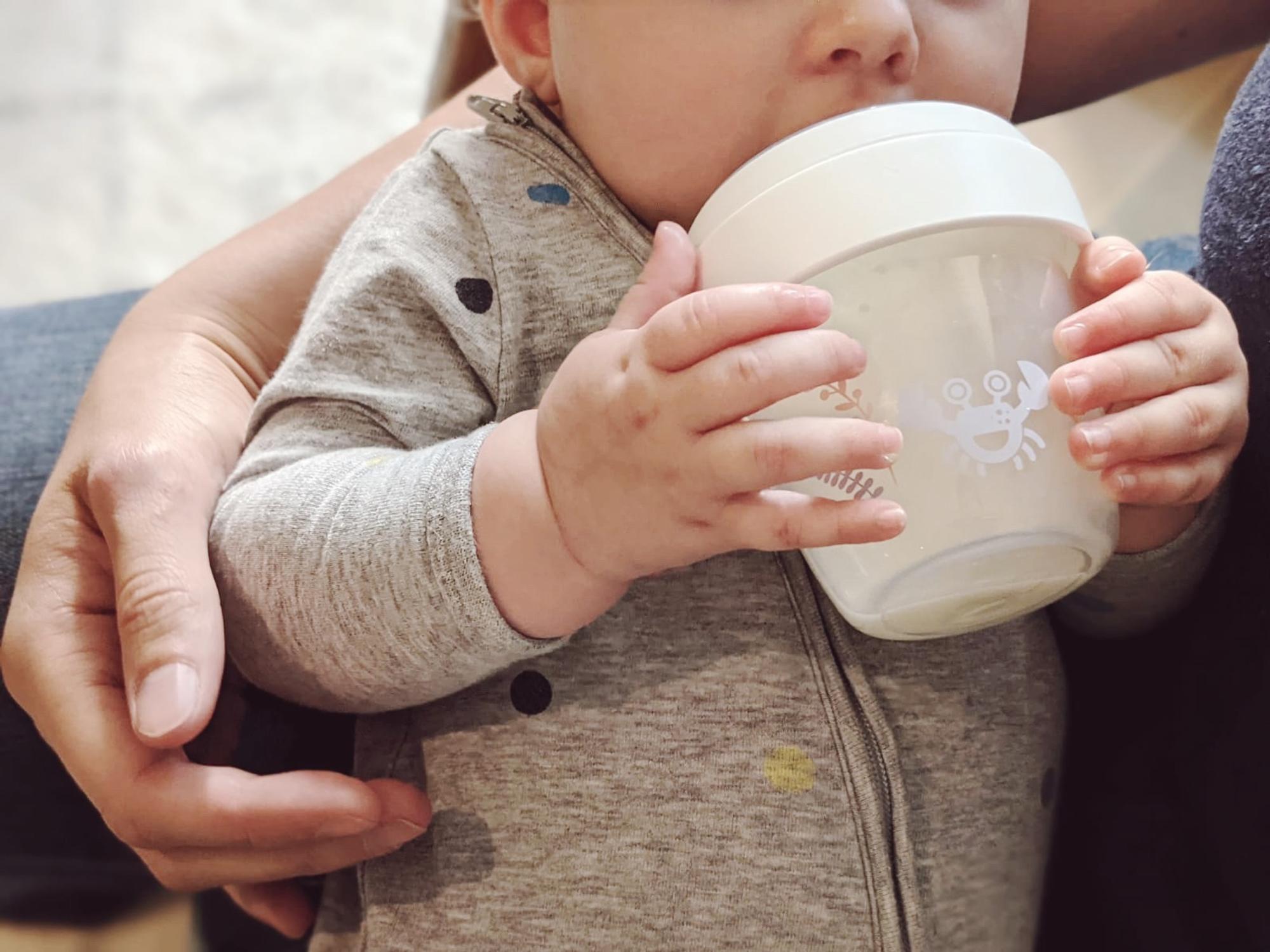 Baby hält die nip-first-moments-Flasche