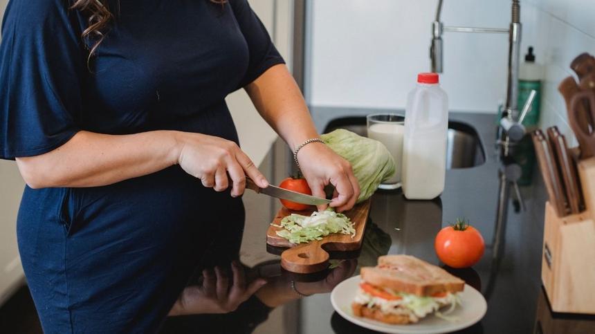 Louwen-Diät: Schwangere Frau schneidet Gemüse