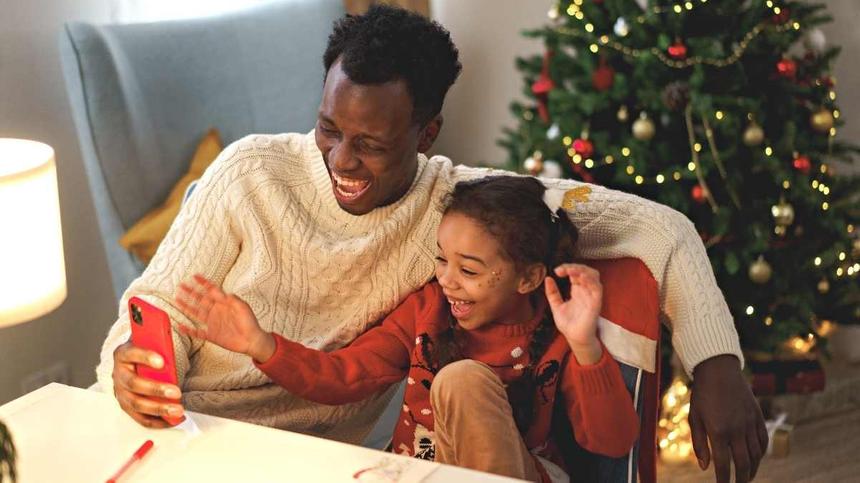 Vater und Tochter machen Fingerspiele zu Weihnachten