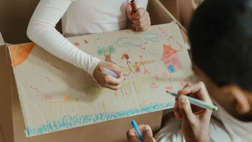 Kinder malen Umzugskarton an