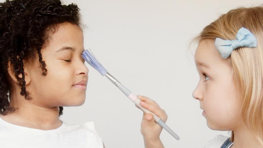 Zwei Mädchen schminken sich mit Kinderschminke