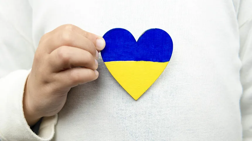 Mädchen hält Herz mit Ukraine-Flagge
