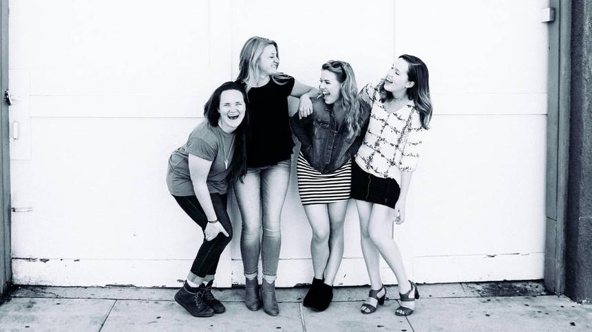 Vier Frauen lachen zusammen
