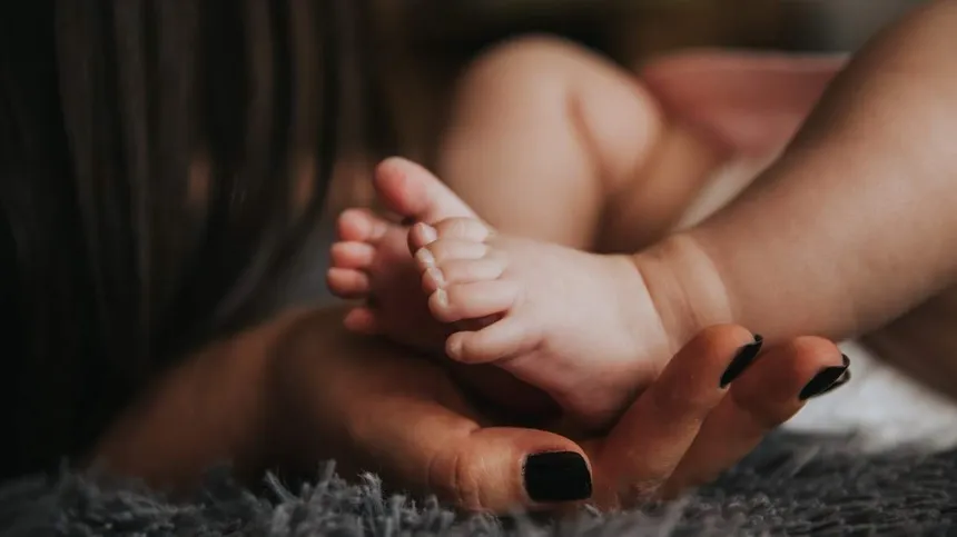 Symbolbild: Mama hält die Füße ihres Babys in der Hand